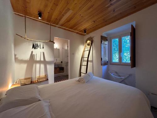 a bedroom with a large white bed and a ladder at Casa da Figueira - Pool and Lounge in Praia do Ribatejo