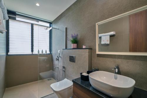 a bathroom with a sink and a toilet and a shower at SaffronStays Pickle & Play in Khandāla