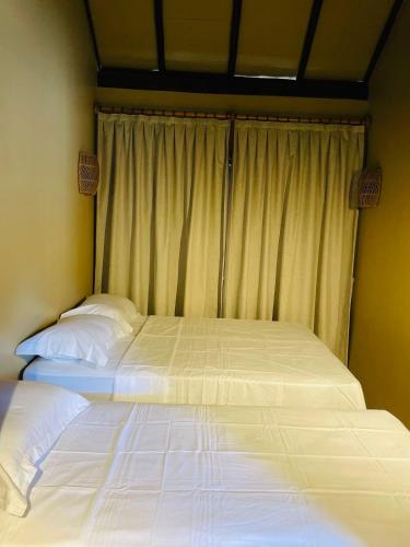 two beds sitting next to each other in a bedroom at Villa Coco e Sol - Casa com Jacuzzi in Amontada