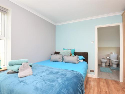 a bedroom with a blue bed and a bathroom at 2 Bed in Morpeth oc-36925 in Widdrington