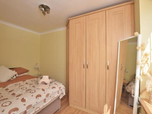 a bedroom with a bed and a large wooden cabinet at 2 Bed in Morpeth oc-36925 in Widdrington