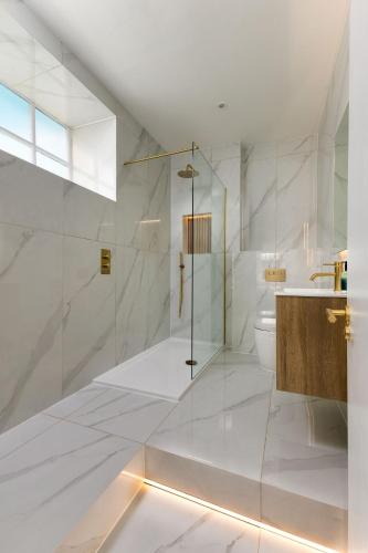 a white bathroom with a shower and a toilet at Blythswood Square Apartments in Glasgow