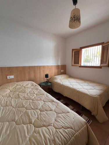 a bedroom with two beds and a window at Orgiva - La Alpujarra in Órgiva