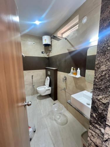a bathroom with a toilet and a sink at Hotel Kalptaru Villas in Debāri
