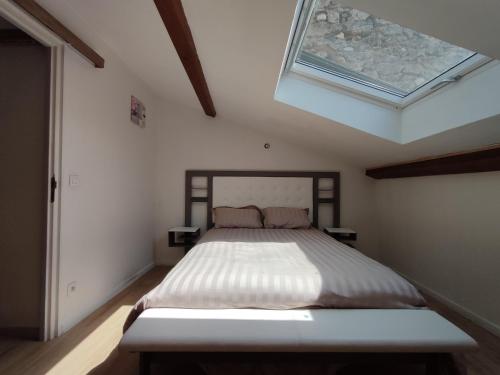 a bedroom with a large bed with a skylight at La Mansarde étoilée in Saint-Marcellin