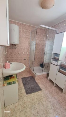 a bathroom with a shower and a sink and a toilet at Studios Dolček in Krvavica
