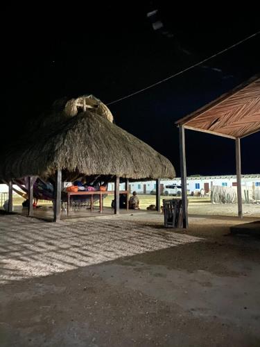 two straw umbrellas on the beach at night at Hotel Cabo Royal in Cabo de la Vela