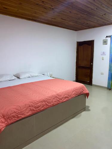 a bedroom with a bed with red sheets and a wooden ceiling at Hotel Cabo Royal in Cabo de la Vela