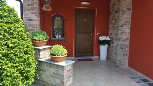 a front door of a house with potted plants at Villa Laura B&B in Fossano
