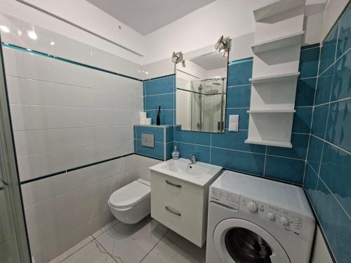 a bathroom with a washing machine and a toilet at Apartament w Centrum III in Ustka