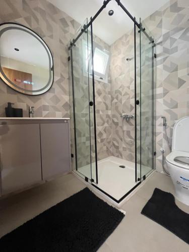 a bathroom with a shower and a toilet and a mirror at Appartement mirador golf 3 in Cabo Negro