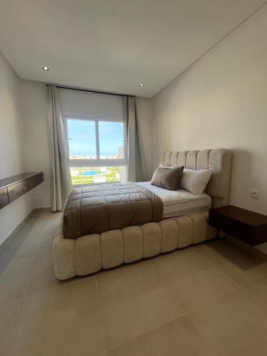 a bedroom with a large bed and a large window at Appartement mirador golf 3 in Cabo Negro