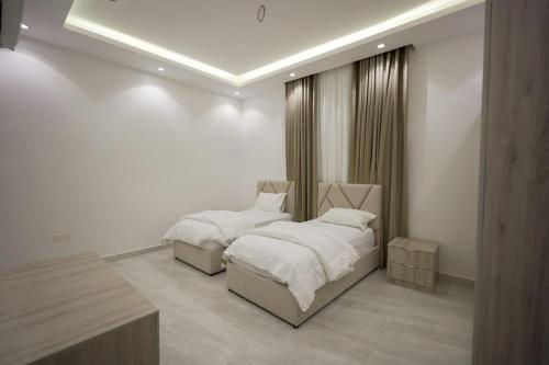 a bedroom with two beds with white sheets at فيلا ابو بندر in Jeddah