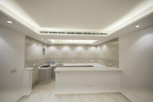 a white kitchen with a sink and a stove at فيلا ابو بندر in Jeddah