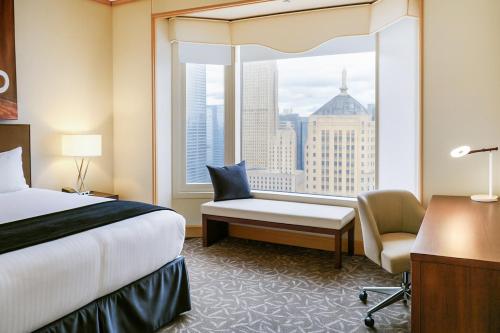 a hotel room with a bed and a window at The Buckingham Hotel in Chicago