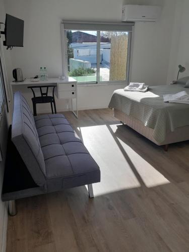 a bedroom with a bed and a chair and a table at Déjalo ser in Nueva Helvecia