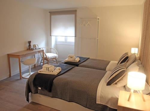 a bedroom with two beds and a table and a desk at Casa Rural Garcés in Lumbier