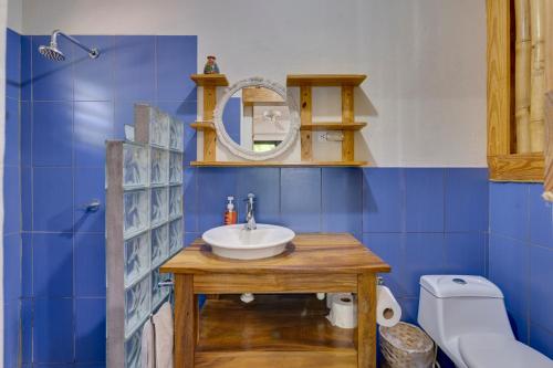 a blue bathroom with a sink and a mirror at Hotel Café Con Leche in Playa Santana