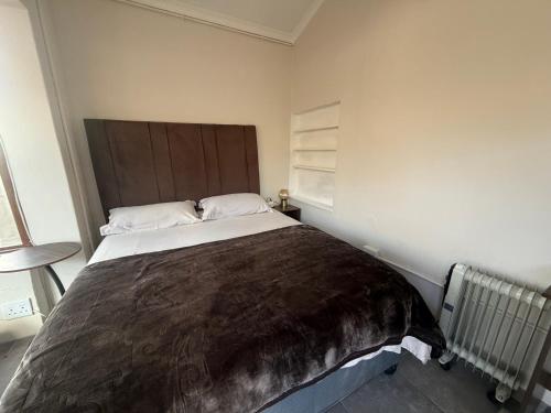 a bedroom with a large bed with a brown blanket at Suite Dreams Cute Studio Flat in Panorama