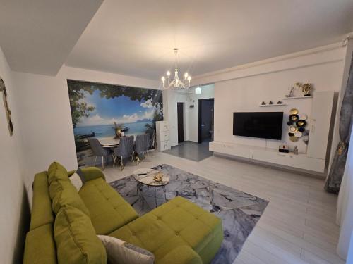 a living room with a green couch and a television at DeLux Apartment -Militari Residence Rosu Chiajna in Dudu