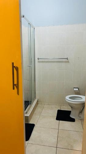 a bathroom with a toilet and a glass shower at DL Apartments in Palatswe