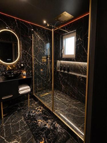 a black bathroom with a shower and a mirror at Obsidian Suite Love Room in Triel-sur-Seine