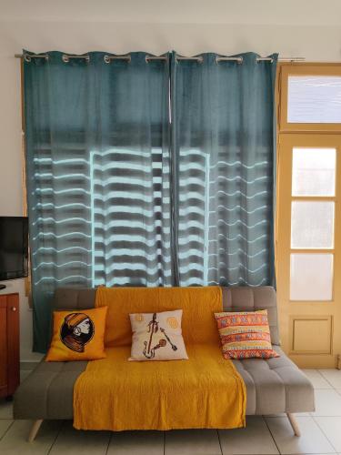 a couch with pillows on it in a living room at Manolia !!! in Kranidi