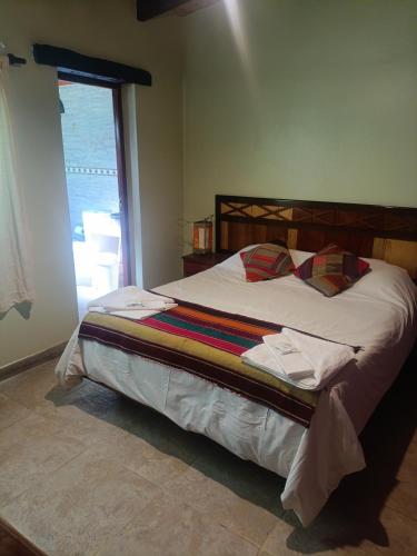 a large bed in a bedroom with a window at Cielo Andino Colonial in Purmamarca