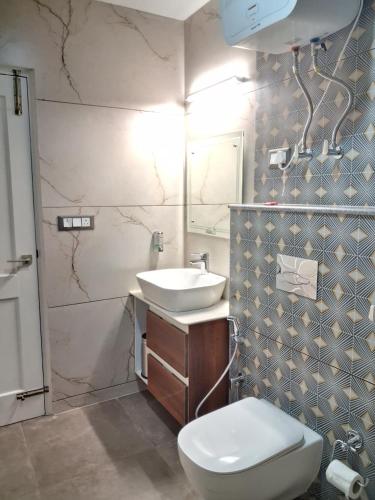 a bathroom with a white toilet and a sink at Vardhn Villa in Sarāhan