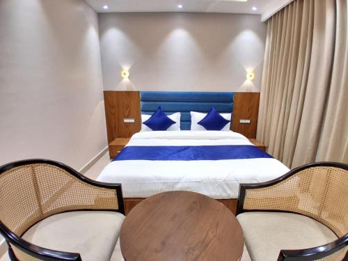 a bedroom with a bed and a wooden table and chairs at Vardhn Villa in Sarāhan