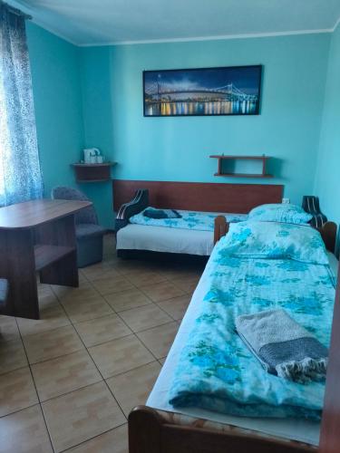a room with two beds and a table in it at Pokoje u Renatki in Chałupy
