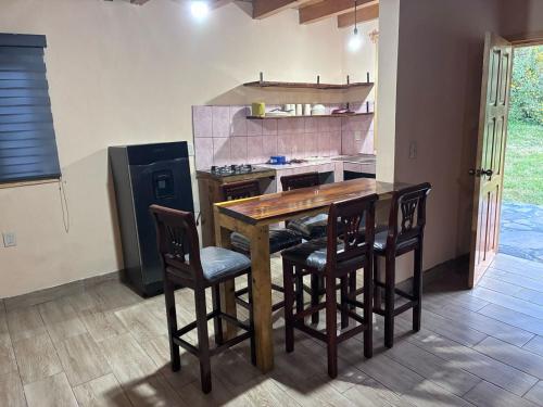 a kitchen with a wooden table with chairs and a refrigerator at Cabañas El Borrego in Mazamitla