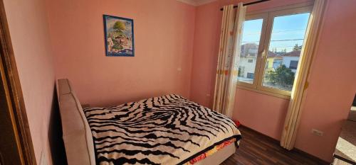 a zebra print bed in a room with a window at Villa Doda in Durrës