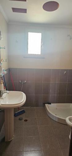 a bathroom with a sink and a toilet and a tub at Villa Doda in Durrës