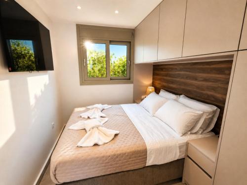 a bedroom with a bed with towels on it at Porto Minimal Oasis in Porto Rafti
