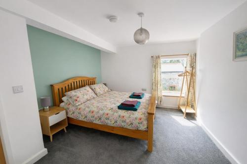 a bedroom with a bed and a window at Swallows Rest Cottage - 3 Bedrooms - Nr Looe in Looe