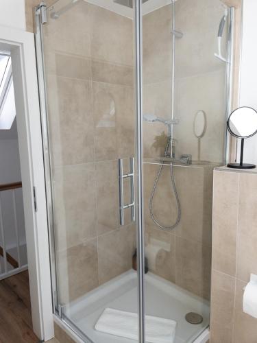 a shower with a glass door in a bathroom at TINY TEUTO HOUSE- Die alte Schusterei in Detmold