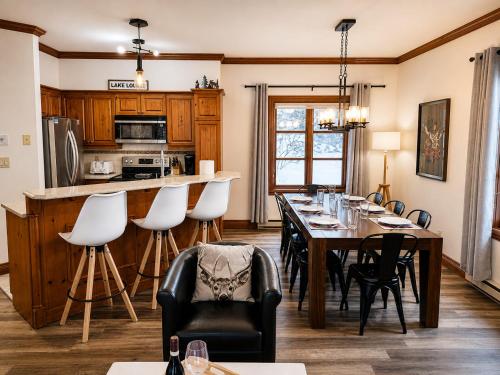 a kitchen and dining room with a table and chairs at TRUE ski inout - large heated pool in summer! in Mont-Tremblant