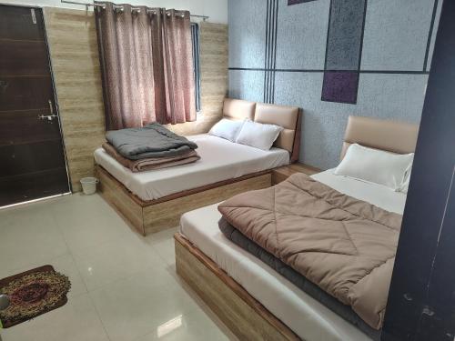 a room with two beds and a window at Hotel Murlidhar in Chikāra