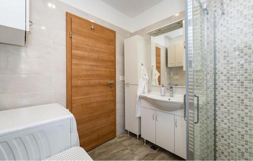 a bathroom with a sink and a wooden door at Apartman in Seline