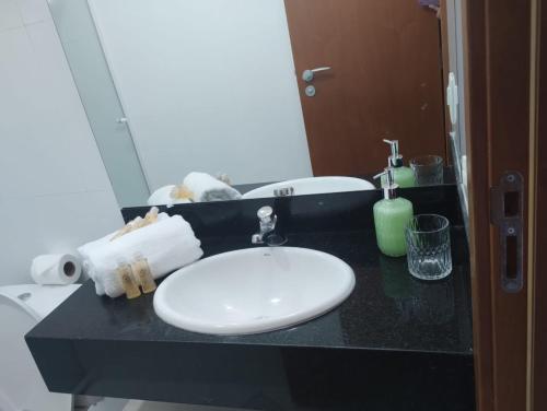 a bathroom with a white sink and a mirror at Apart Itacuruçá - Hotel Porto Marina in Mangaratiba