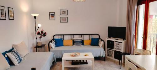 a bedroom with a bed and a couch and a tv at Polynikis Apartment in Nikiti