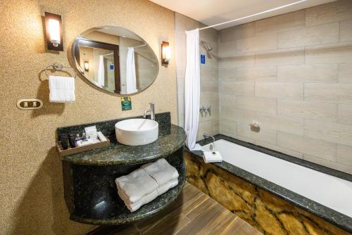 a bathroom with a sink and a bath tub at Baldi Hot Springs Hotel & Spa in Fortuna