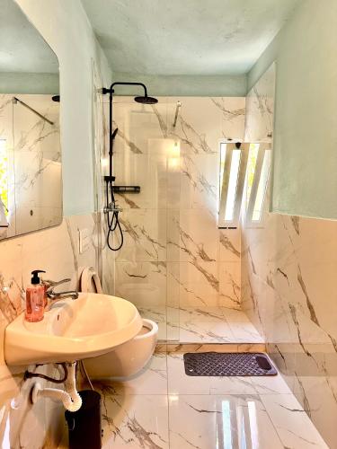 a bathroom with a sink and a shower at Sekretet e Luginës Restaurant - Hostel - Camping in Vau i Dejës