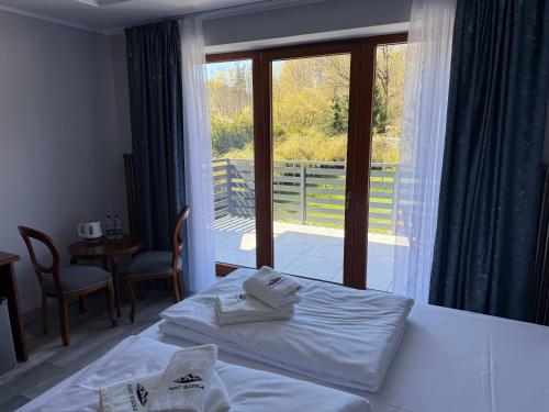 a bedroom with a bed and a view of a balcony at Pensjonat Nad Rzeką in Wisła