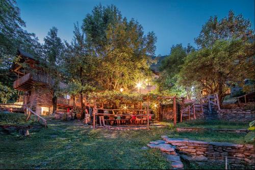 a patio with tables and chairs in a yard at night at Hostelleria in Linescio