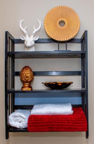 a shelf with towels and a plate and a mirror at Guesthouse Gabby in Klerksdorp