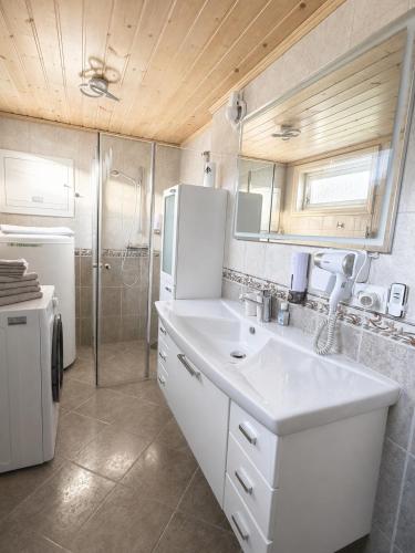 a kitchen with a white sink and a refrigerator at D&C Norway in Kristiansand