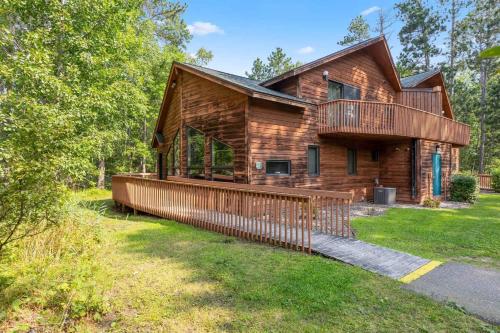 a log cabin with a large porch and a deck at Causeway On Gull - 2 Bedroom in Nisswa