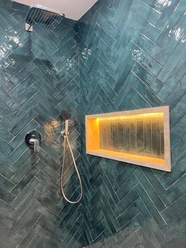 a bathroom with a shower with a tiled wall at Apparemment Martil Sofia bay in Martil